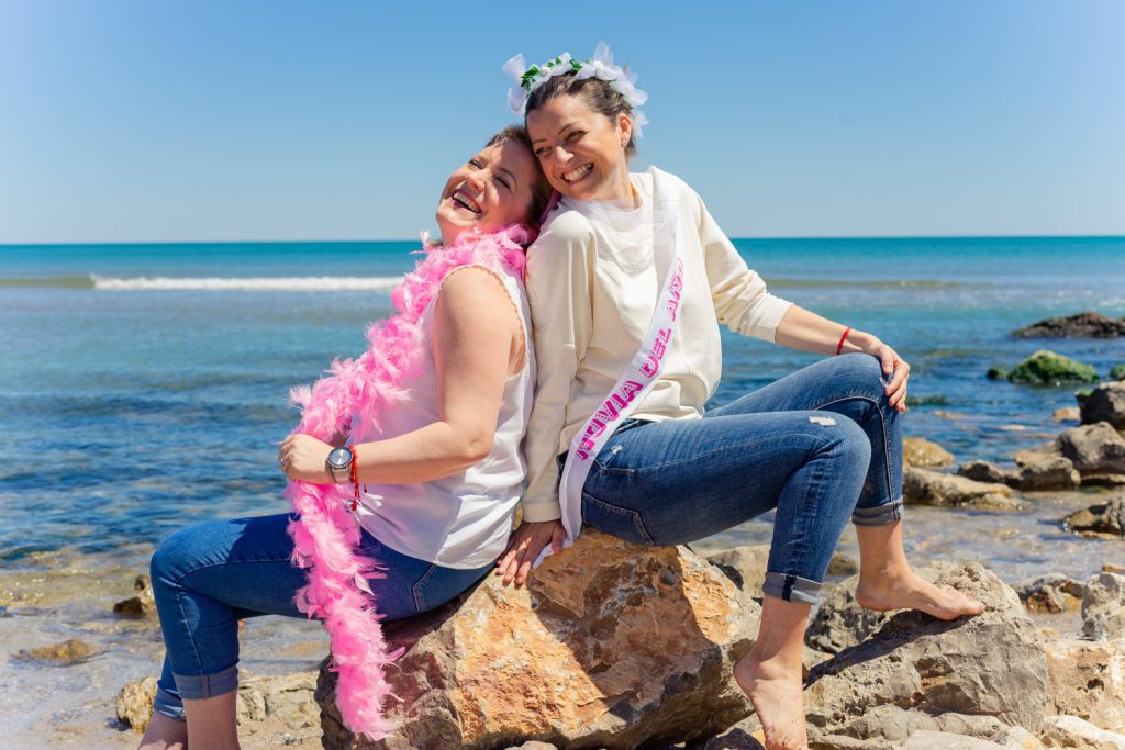 Dos amigas riendo en paisaje de mar y rocas en despedida de soltera. Carlos Gimart Fotógrafo
