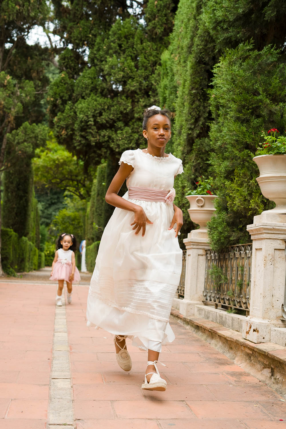 niña vestida de comunión corre por parque