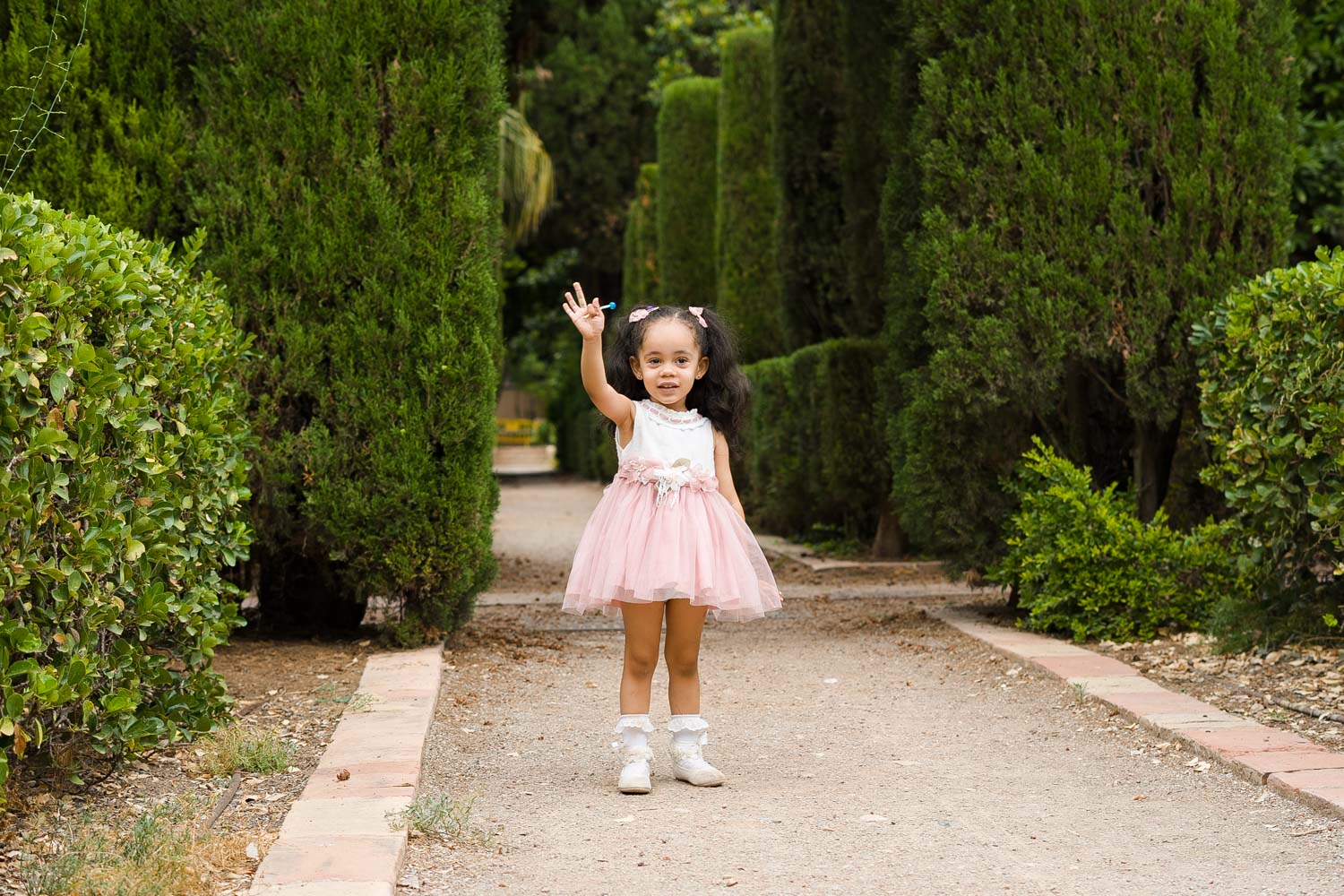 niña saluda en sesión de comunión