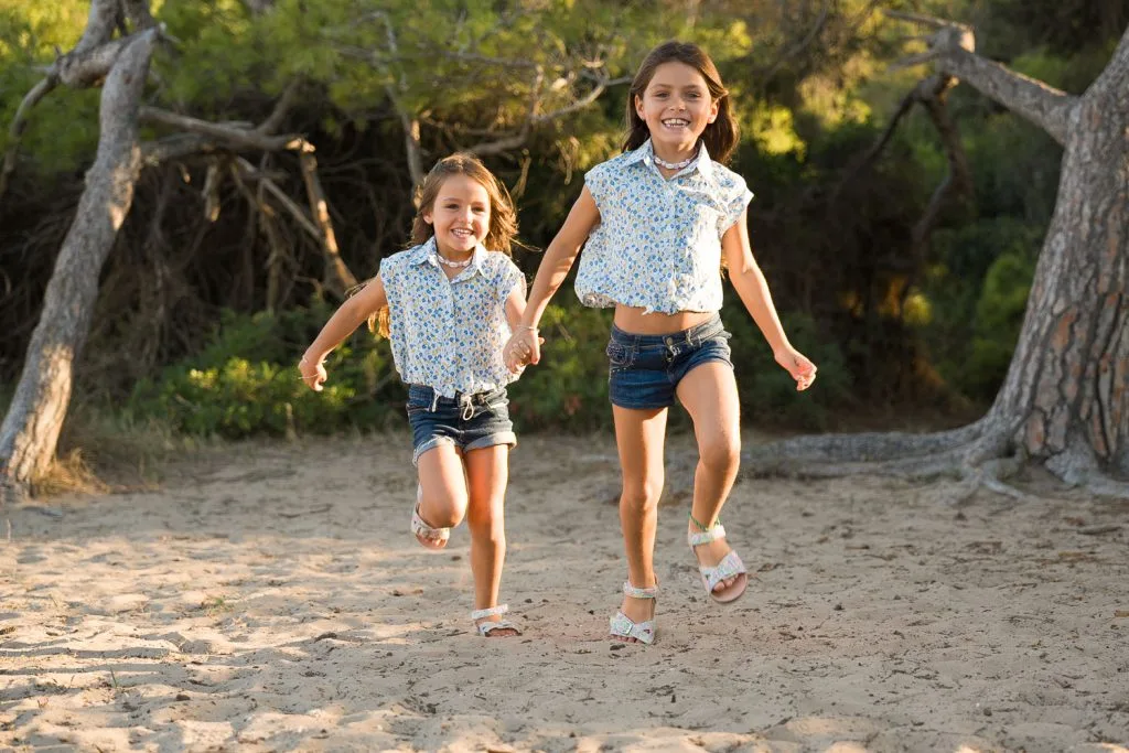 dos hermanas pequeñas corren por campo en Valencia