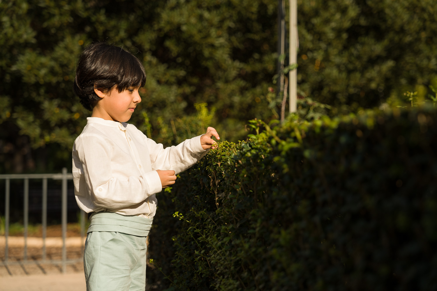 infante jugando con plantas en parque