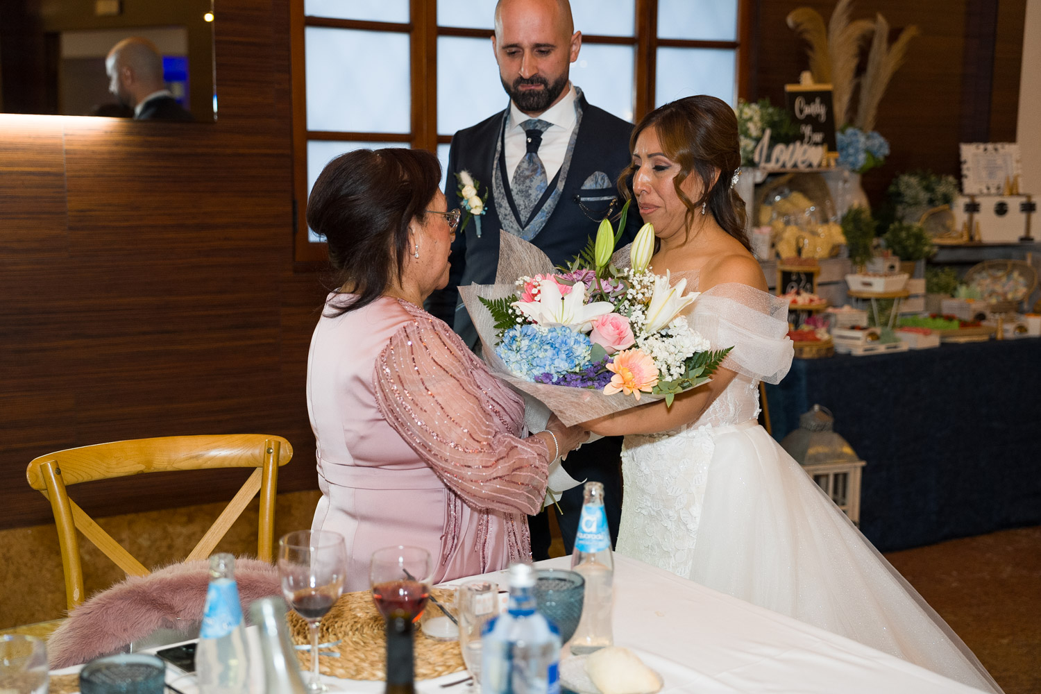 novia da ramo de flores a su madre y la abraza