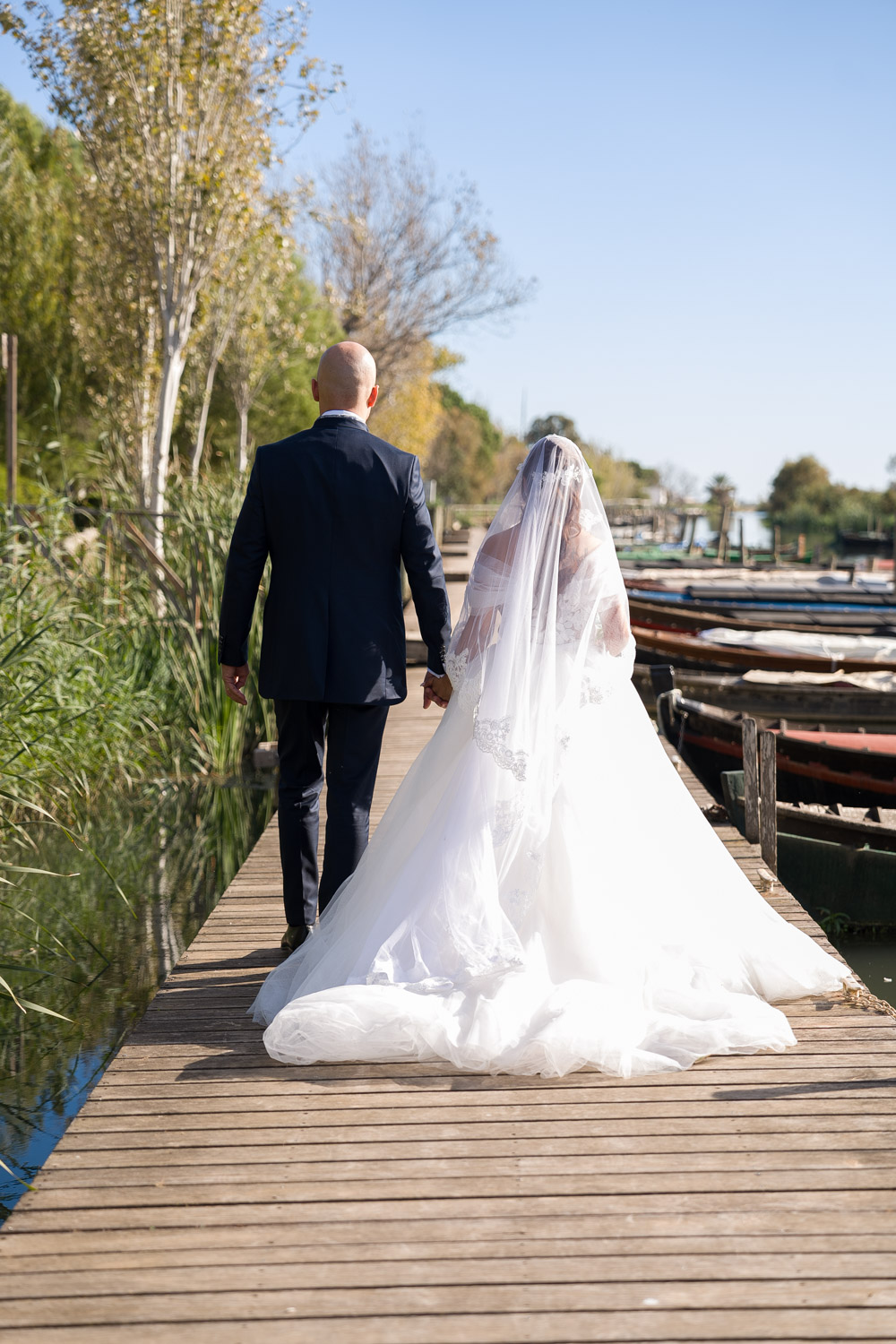 novios pasean por muelle de madera después de casarse
