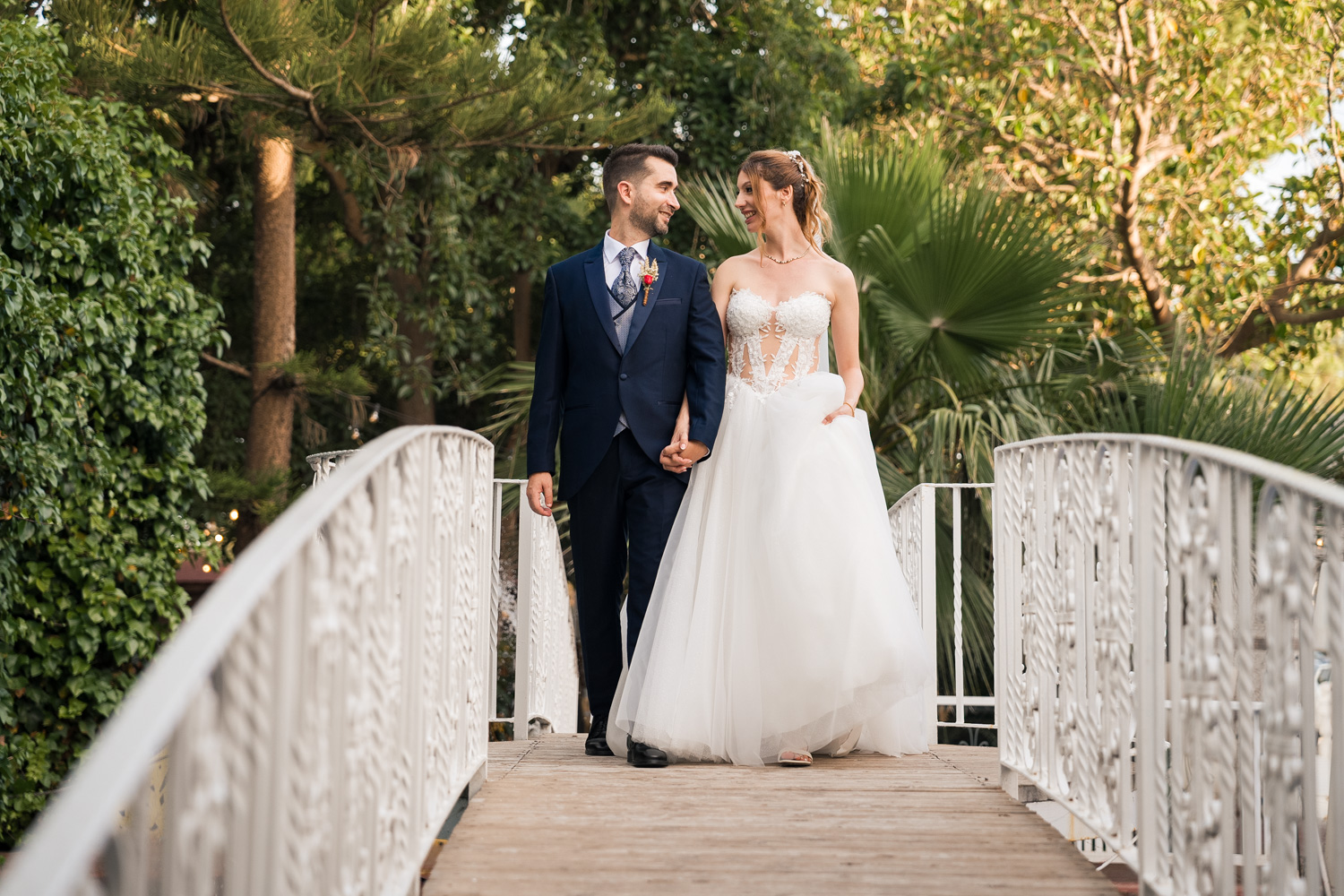 recién casados caminan por puente en Masía de Santarrita