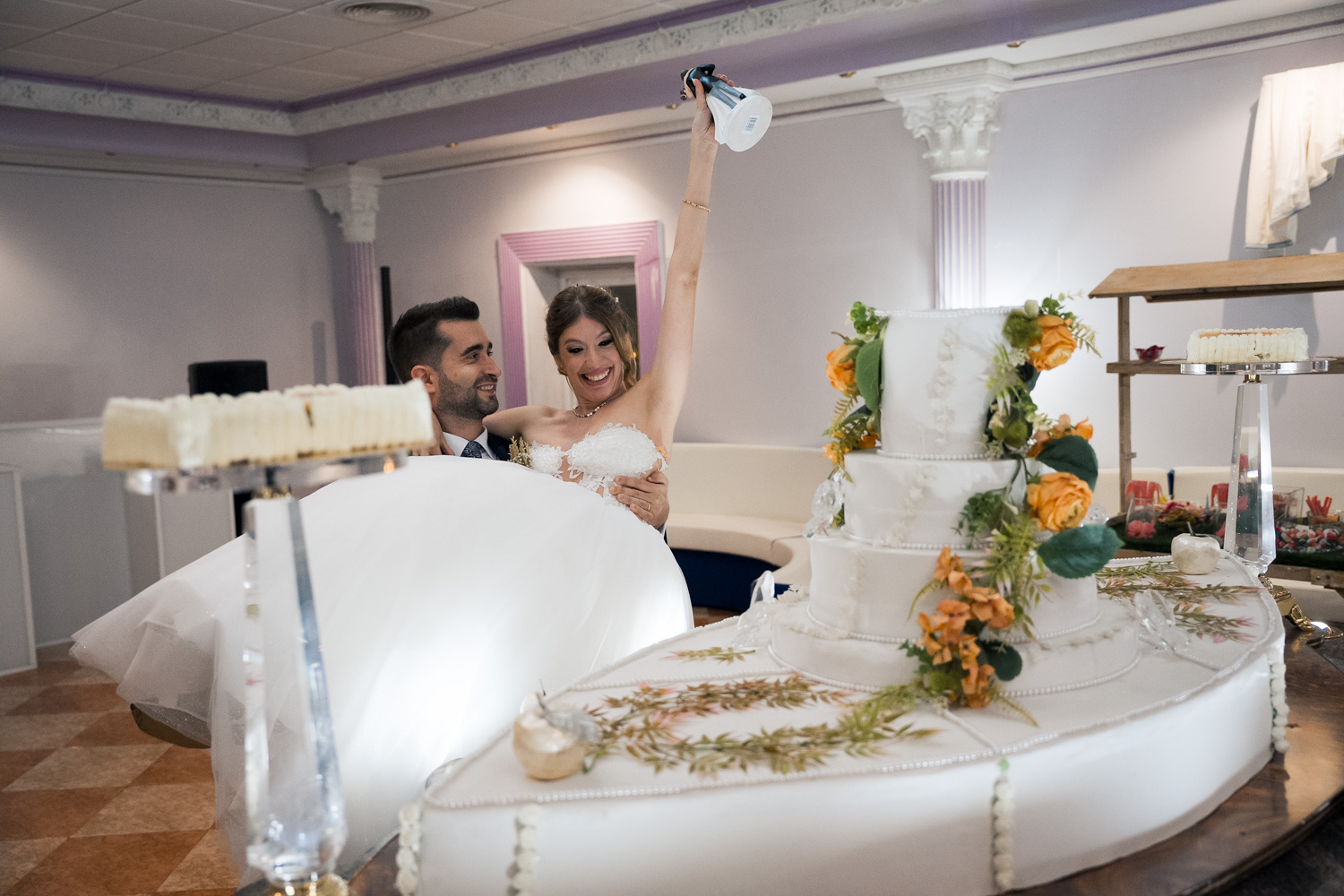 novios de boda cogen muñeco de la tarta