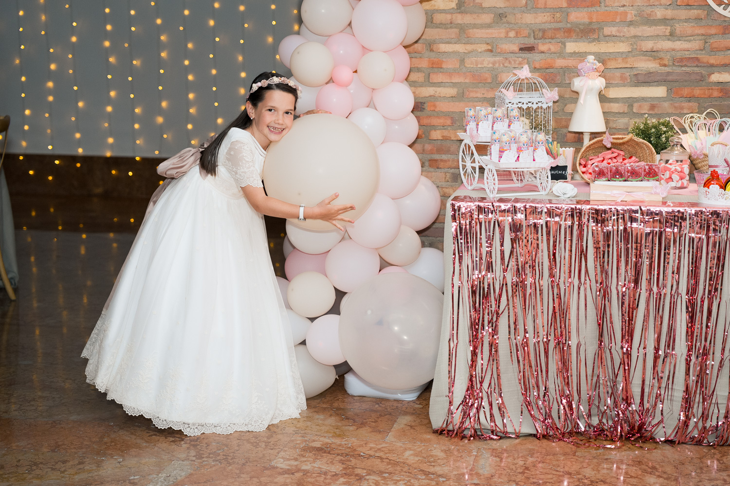 niña abraza globos en su comunión