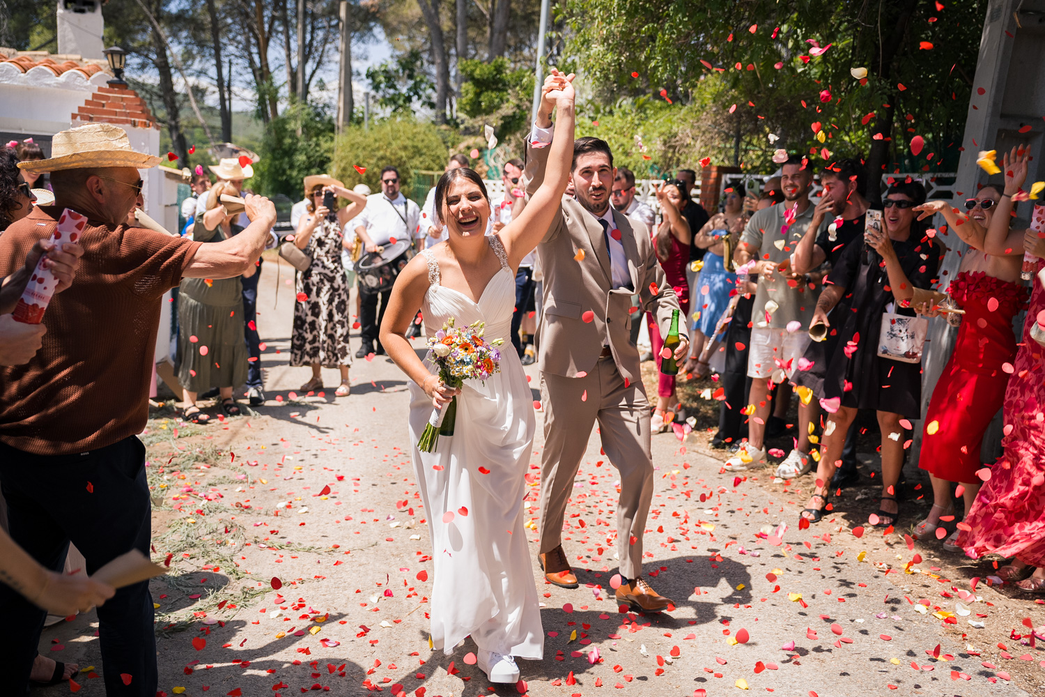 novios corren e invitados les lanzan pétalos de flores